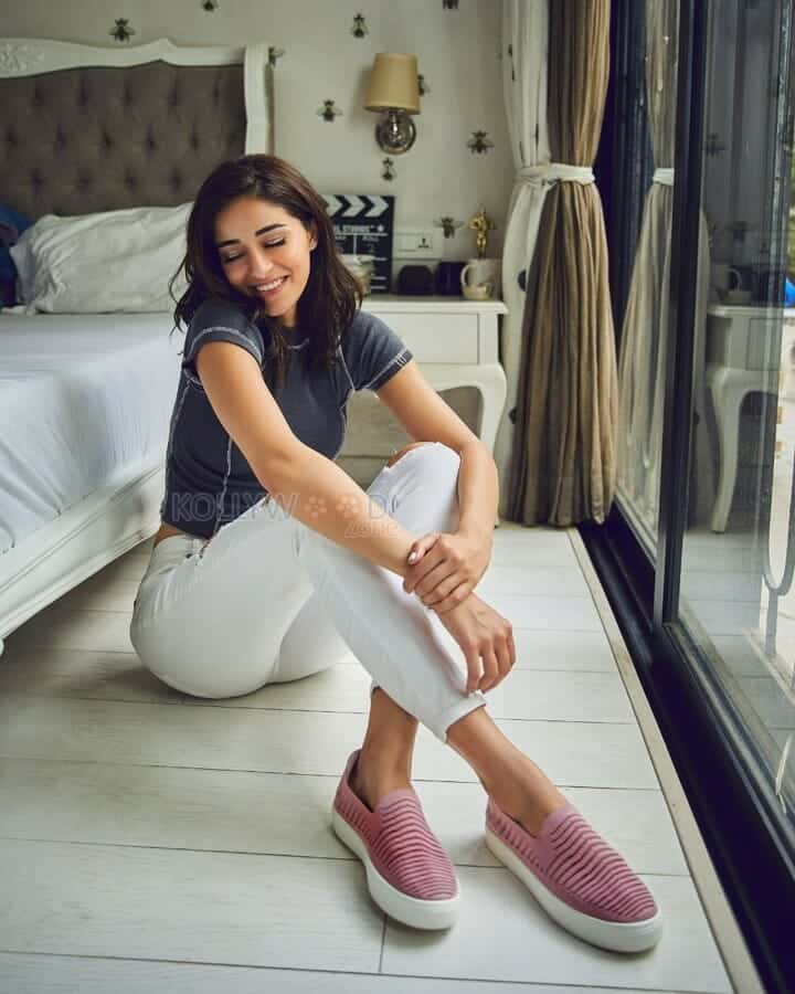 Ananya Panday sitting near the bed in a white pant photo 01