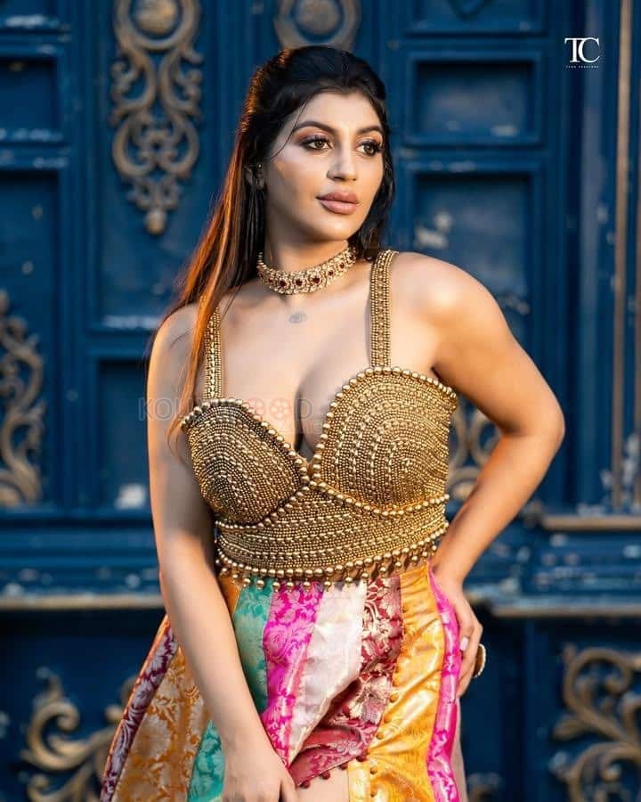 Tamil Glamour Actress Yashika Aannand in a Embellished Gold Bralette Top with a Multi Colored Thigh Slit Skirt Photos 01