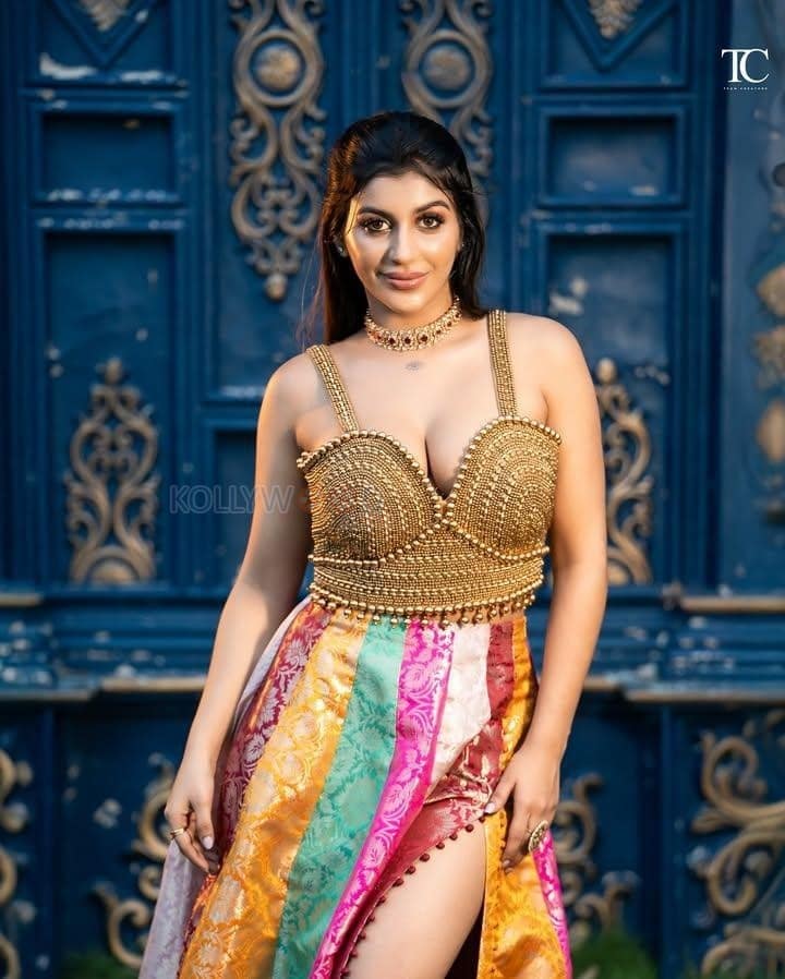 Tamil Glamour Actress Yashika Aannand in a Embellished Gold Bralette Top with a Multi Colored Thigh Slit Skirt Photos 02
