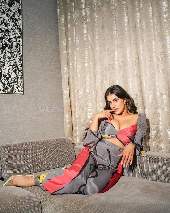 Eagle Actress Kavya Thapar Busty Cleavage in a Stylish Plunging Neckline Pink and Grey Outfit on a Sofa Photos 04