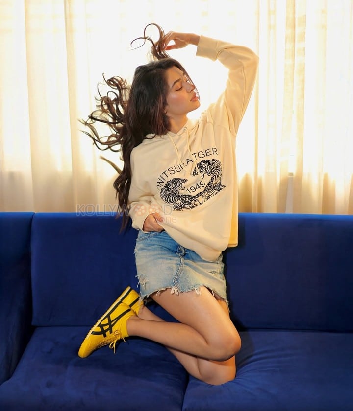 Sexy and Hot Krithi Shetty in a Cream Hoodie with a Blue Denim Mini Shorts Photos 04