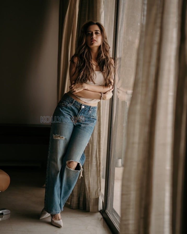 Stunning Ashika Ranganath in a White Crop Top and Ripped Blue Jeans Photos 02