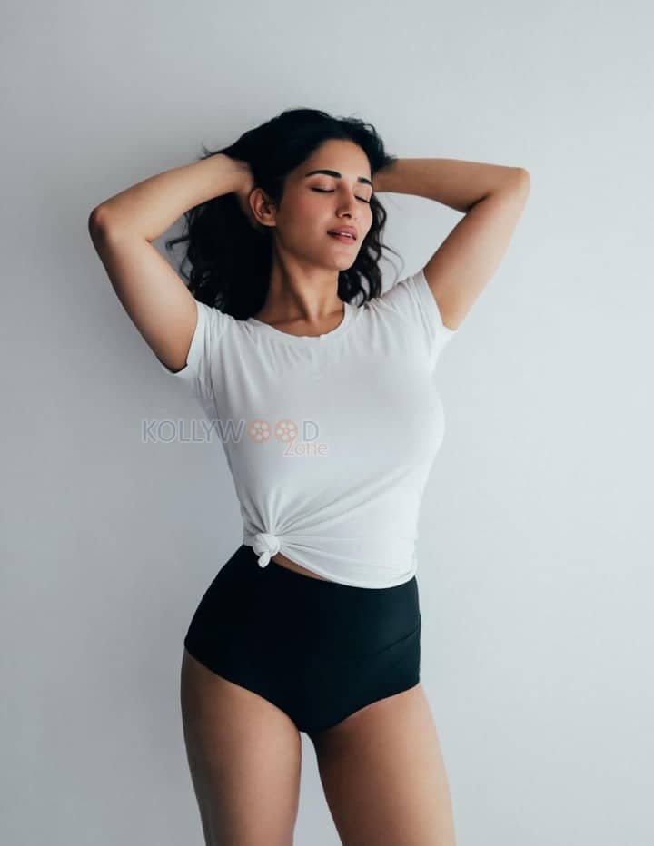 Charming Beauty Ruhani Sharma in a White Knotted T Shirt with a High Waisted Black Mini Shorts Photos 05