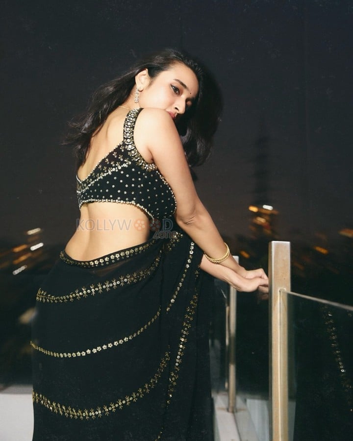 Sexy Nuveksha in a Black Saree with Delicate Golden Sequin Stripes and a Sleeveless Blouse Pictures 09