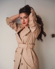 Sexy Actress Avneet Kaur in a Double Breasted Beige Trench Coat with a Black Lace Top and Black Sheer Tights Photos 02