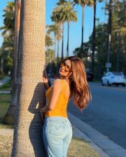 Stylish Actress Avneet Kaur in a Orange Tank Top and Blue Jeans Photos 05