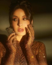 Actress Nora Fatehi in a Gold Bodycon Sparkly Dress Photos 01