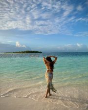 Breathtaking Actress Malavika Mohanan in a White Bikini Top and Floral Beach Sarong Photos 04