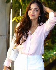 Charming Actress Malavika Mohanan in a Pale Pink Sheer Shirt White Trousers Photos 02