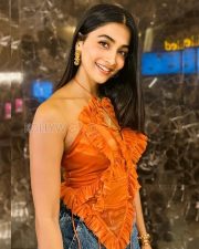 Fashionable Actress Pooja Hegde in an Orange Ruffled Halter Top and Wide Leg Jeans Photos 01