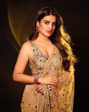 Gorgeous Nidhhi Agerwal in a Golden Sequinned Netted Saree with a Deep Cleavage Sleeveless Blouse Photos 01