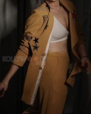Mookuthi Amman 2 Actress Regina Cassandra in a Mango Yellow Embroidered Blazer with Matching Mustard Yellow Straight Leg Pants and White V Neck Bralette Photos 02