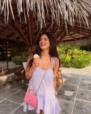 Playful Actress Malavika Mohanan in a Lavender Tie Shoulder Ruffle Mini Dress Photos 01