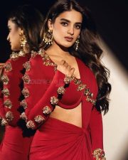 The RajaSaab Actress Nidhhi Agerwal in a Red Long Sleeved Golden Floral Top with a Red Draped Skirt Photos 01