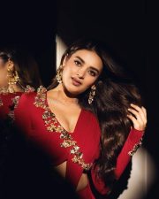 The RajaSaab Actress Nidhhi Agerwal in a Red Long Sleeved Golden Floral Top with a Red Draped Skirt Photos 03
