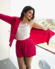 Bazooka Actress Iswarya Menon in a White Halter Neck Lace Top with a Vibrant Red Pink Shirt and Matching Shorts Photos 02