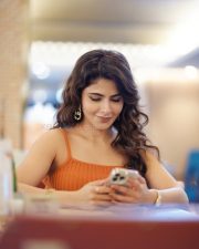 Stylish Iswarya Menon in an Orange Ribbed Crop Top with a High Waisted Blue Jeans Photos 02
