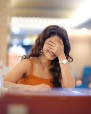 Stylish Iswarya Menon in an Orange Ribbed Crop Top with a High Waisted Blue Jeans Photos 04