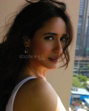 Attractive Pragya Jaiswal in a White Sports Bra with Blue Checkered Plaid Shirt and High Waisted Frayed Denim Shorts Photos 05