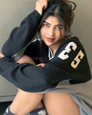 Stylish Actress Srijita Ghosh in a Oversized Varsity Sweater and Plaid Skirt Photos 02