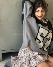 Stylish Actress Srijita Ghosh in a Oversized Varsity Sweater and Plaid Skirt Photos 03