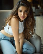 Casual Beauty Krithi Shetty in a White Sleeveless Crop Top and Light Blue Denim Jeans Photos 02