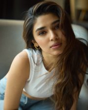 Casual Beauty Krithi Shetty in a White Sleeveless Crop Top and Light Blue Denim Jeans Photos 03