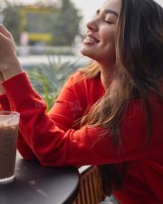 Vaa Vaathiyaar Heroine Krithi Shetty in a Red V Neck Knit Sweater and a High Waisted Light Blue Denim Shorts Photos 01