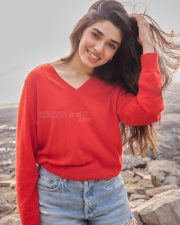 Vaa Vaathiyaar Heroine Krithi Shetty in a Red V Neck Knit Sweater and a High Waisted Light Blue Denim Shorts Photos 05