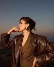 Toaster Actress Sanya Malhotra in a Long Structured Brown Leather Trench Coat with a Tailored Pinstripe Corset Style Vest with a Wide Leg Pinstripe Pants Photos 07