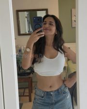 Candid Ruhani Sharma Navel in a White Ribbed Crop Top and Ripped Denim Jeans Photos 01