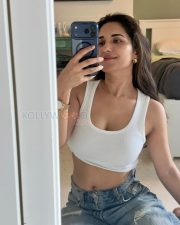 Candid Ruhani Sharma Navel in a White Ribbed Crop Top and Ripped Denim Jeans Photos 04