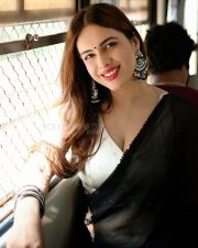Sexy Neha Malik in a Black Saree and White Blouse in a Train Photos 02