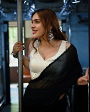 Sexy Neha Malik in a Black Saree and White Blouse in a Train Photos 03