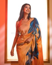 Dazzling Meenakshi Chaudhary in a Vibrant Orange Printed Saree with a Sleeveless Blouse Photos 02