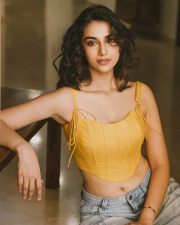 Winsome Actress Meenaakshi Chaudhary in a Yellow Lace Up Crop Top and Jeans Photos 01