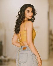 Winsome Actress Meenaakshi Chaudhary in a Yellow Lace Up Crop Top and Jeans Photos 02
