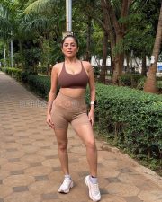 Confident Actress Kate Sharma in a Brown Sports Bra Tan High Waist Biker Shorts White Sneakers Photos 06
