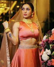 SOS Kolkata Actress Mimi Chakraborty in a Coral Orange Sleeveless Silk Crop Blouse and a Matching Lehenga Skirt with Sheer Net Dupatta Pictures 03